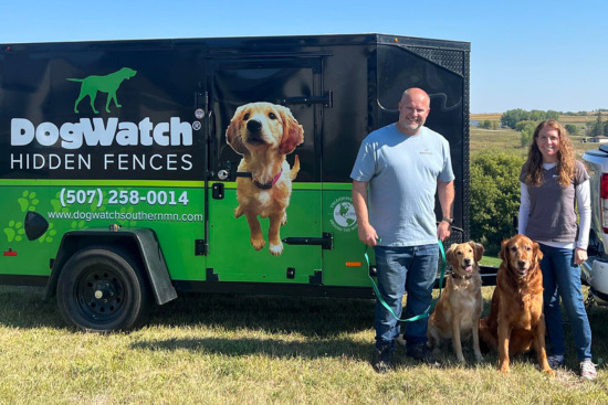 Jason and Teresa Nelson and their dogs standing in front of their DogWatch vehicle